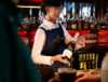 Colour photograph of bar staff with champagne bottle